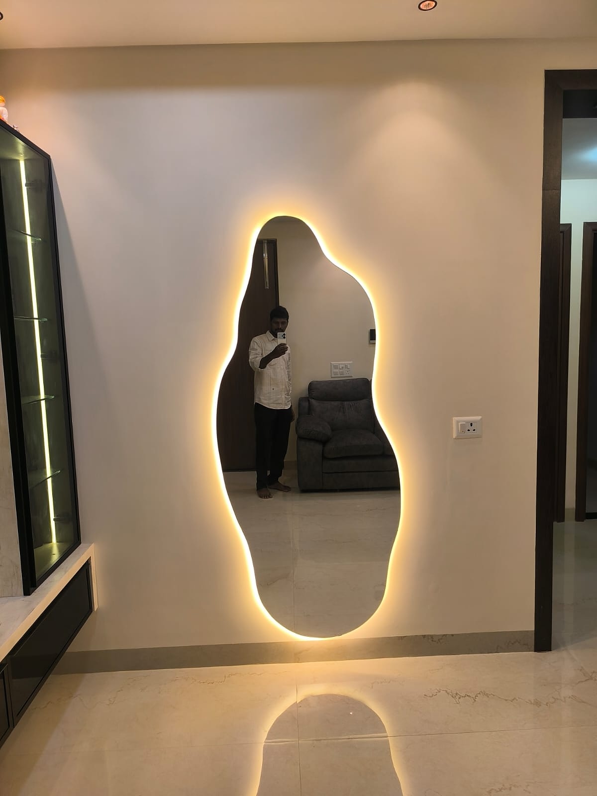 Organic shaped backlit mirror in hallway