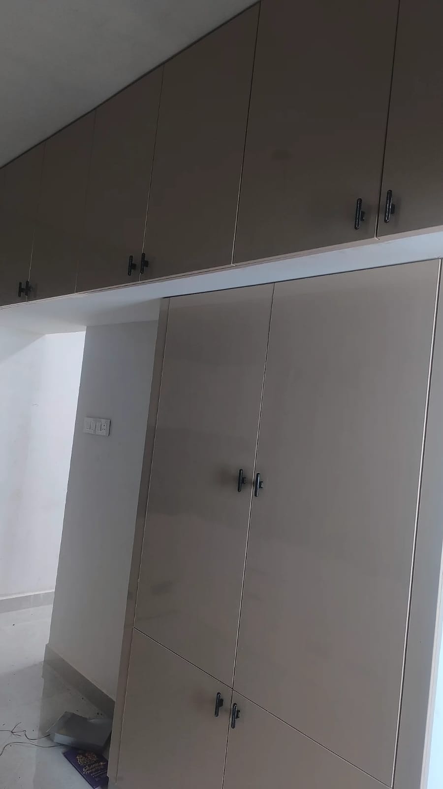 Tall taupe wardrobe with overhead cabinets